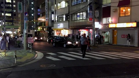People crossing the street at night while a car stops to let them pass, Stock Footage 124659409