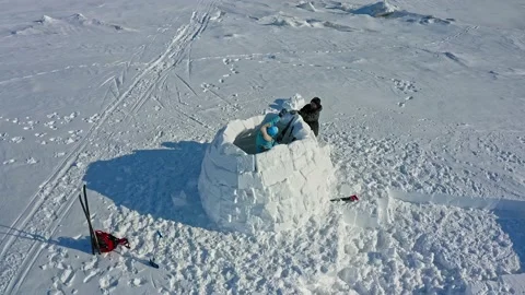 People cut and fix blocks with metal saw building igloo Stock Footage 133829016