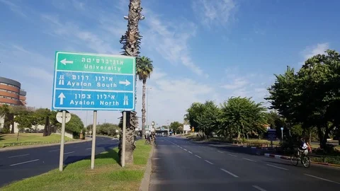 People cycle on empty Rokach road, Yom Kippur 2016, highway and university sign Stockbeeldmateriaal 80261392
