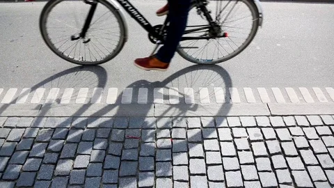 People cycling in Copenhagen, focus on bicycle shadows Stock Footage