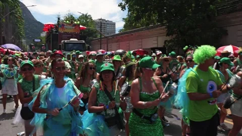 People dance and play instruments during a Rio Carnaval parade near Jardim Stock Footage 337410642