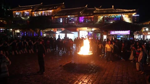 People dance around a fire in the old town of Lijiang, Yunnan province, China Stock Footage 336749915