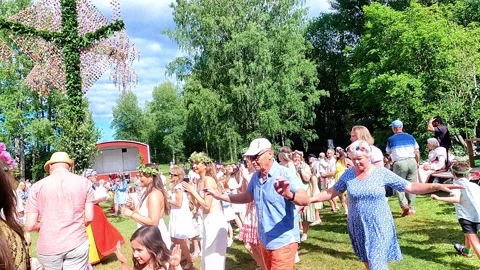 People dance around the midsummer pole during the big holiday in Sweden. The Video stock 315087582