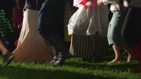 People dance in the midsummer night in the middle of the meadow in folk costumes Stock Footage 253394962