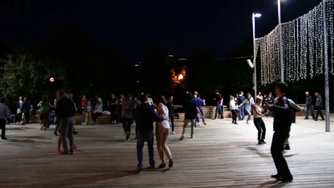People dancing and having fun under the open sky in a summer park 動画素材 107689925
