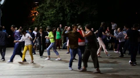People dancing and having fun under the open sky in a summer park Stock Footage 107689931
