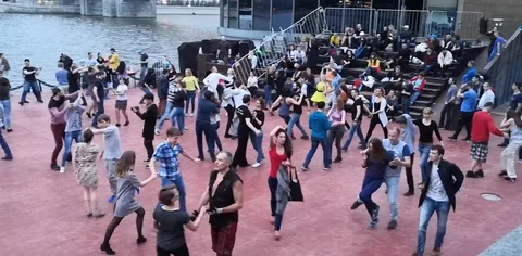 People dancing and having fun under the open sky in a summer park Stock Footage 107689963
