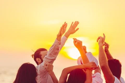 People dancing at the beach with hands up. concept about party, music and people Stock Photos