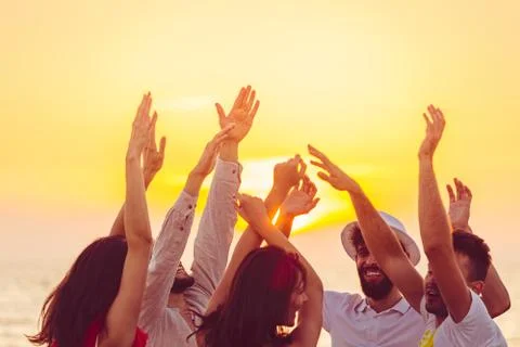 People dancing at the beach with hands up. concept about party, music and people Stock Photos