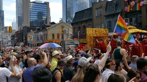 People dancing on glittered up float in gay parade in front of crowd Stock Footage 88417313