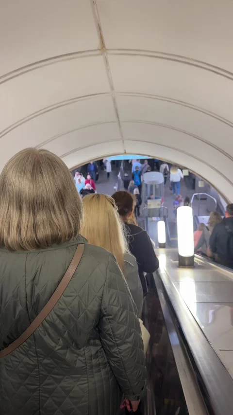 People descend on an escalator inside a metro station as part of everyday city m Stock Footage 338000712