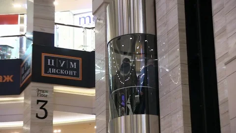 People descend in transparent glass elevator cabin in big mall Stock Footage 101739836