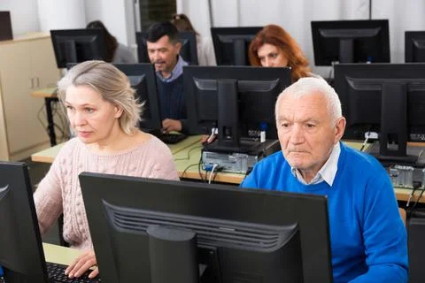 People of different age studying in computer class Fotos de archivo