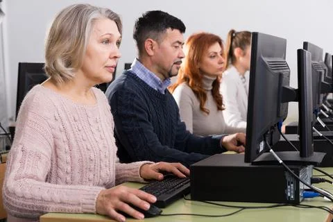 People of different age studying in computer class Fotos de archivo