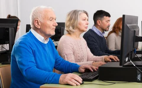 People of different age studying in computer class Fotos de archivo
