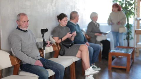 People of different ages sit and wait in line waiting to see a social worker Stock Footage 331316460