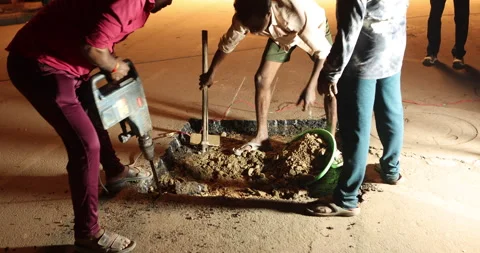People digging pit on tar road Night Stock Footage 324524830