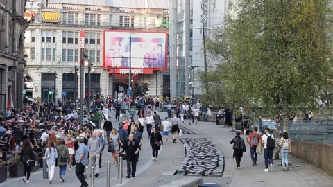 People dining and drinking outside the restaurants of Manchester Corn Exchange. Stock Footage 94517103