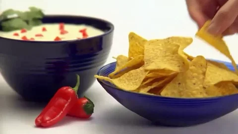 People dipping corn chips into guacamole dip Stock Footage 102717471