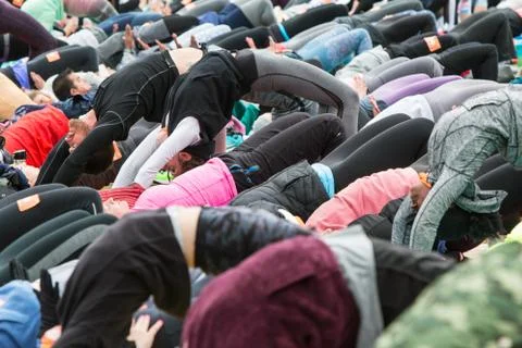 People Do Upward Bow Pose In Large Outdoor Yoga Class Stock Photos