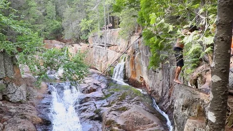 People doing back flips off of a rock cliff Stock Footage 127307255