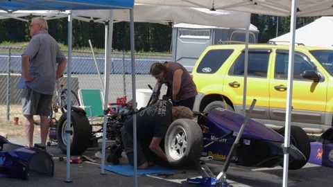 People doing maintenance on opened wheel racing car. 스톡 동영상 157782991