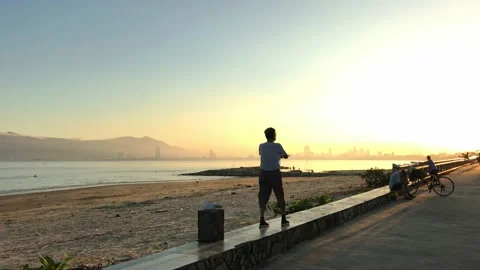 People doing morning exercise at sunrise on the beach of Da Nang, Vietnam Stock Footage 143990053
