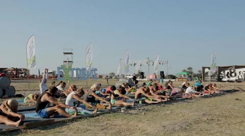 People doing stretching during a training yoga on the beach Stock Footage 60682692