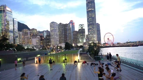 People doing workout in Tamar Park, Hong Kong Stock Footage 124987349