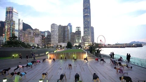 People doing workout in Tamar Park, Hong Kong Stock Footage 124987393