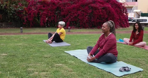 People doing yoga class keeping social distance at city park Stock Footage 151682232