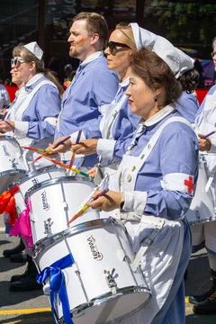 People dressed as nurses drumming at Pride parade Stock Photos