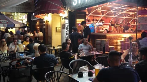 People drinking and smoking at open terrace bar at night in Asia - 4k footage Stock Footage 245554226