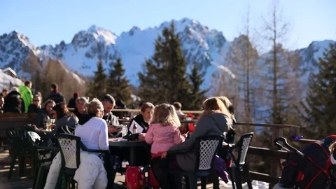 People Drinking beer and taking sun under Snow Mountain Stock Footage 122815790