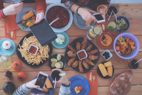 People with drinks while sitting at the dining table Stock Photos