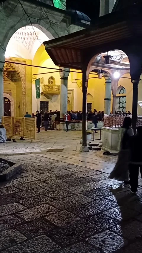 People during night pray inside mosque courtyard  at Bascarsija in Sarajevo. Stock Footage 246825465