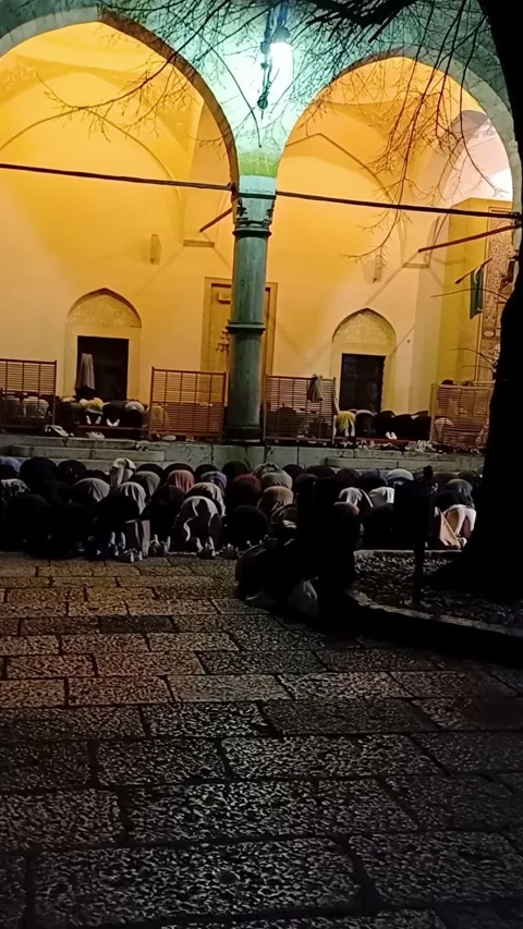 People during night pray inside mosque courtyard  at Bascarsija in Sarajevo. 動画素材 246825473
