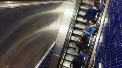 People during rush hour on escalators in subway on Marienplatz in Munich Stock Footage 135912699
