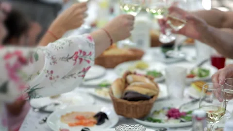 People eat at a large table and clink glasses, a festive table Stock Footage 245606244