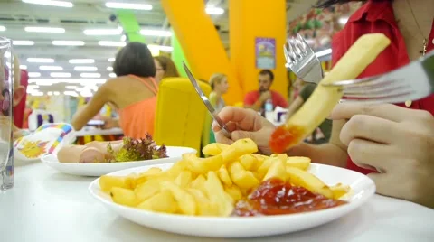 People eat sausages and fries using fork and knife Stock Footage