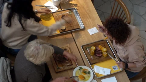 People eat at a table in a restaurant. View from above. Stock Footage 118770892