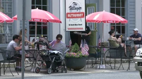 People eating under market umbrellas at a sidewalk cafe (2 of 3) Stock Footage
