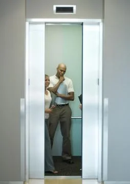 People in elevator, doors closing Stock Photos