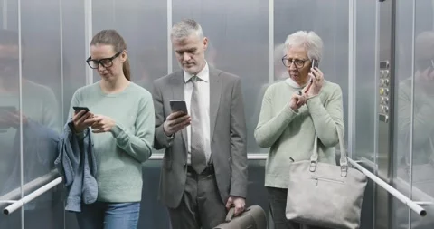 People in the elevator using their smartphones and ignoring others Stock Footage 306149812