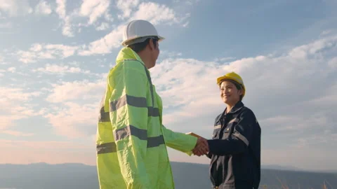 People engineer are shaking hand in a field wearing a protective helmet Stock Footage 169241345