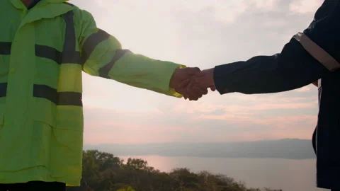 People engineer are shaking hand in a field wearing a protective helmet Stock Footage 169241374