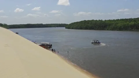People enjoy river activities next to dunes - Barreirinhas, Brazil Stock-Footage 331517436