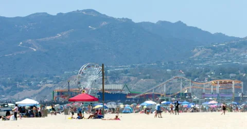People enjoy summer time during the heat wave in Santa Monica Beach 4K RAW Stock Footage 64830010