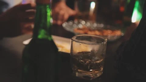 People enjoying drinks and snacks together in dark ambiance Stock Footage 325445703