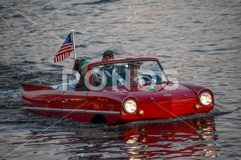 People enjoying ride in red amphibious car Stock Photos